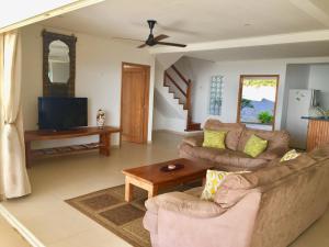 a living room with a couch and a table at Blue Horizon Villas in Pointe Au Sel 