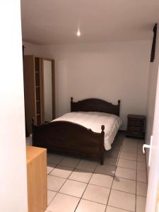 a bedroom with a bed and a tiled floor at Chambres en collocation in Charvonnex