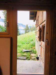 an open door of a house with a view of a field at Giferspitz Gstaad in Gstaad
