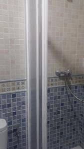 Centro Histórico de Málaga في مالقة: حمام به دش وبه بلاط ازرق