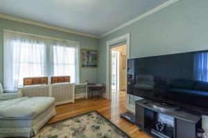 a living room with a couch and a flat screen tv at Charming Harvard Victorian in Cambridge