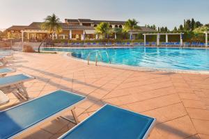a large swimming pool with blue tables and chairs at Lantana Resort Hotel&Apartments in Pula