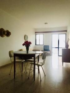 stół jadalny z krzesłami i wazonem kwiatów na nim w obiekcie Apartment with stunning sea view w mieście Pachyammos