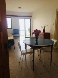 Una habitación con una mesa con un jarrón de flores. en Apartment with stunning sea view en Pachyammos