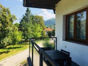 a balcony with a wooden table and a window at Apartments Konak in Visoko