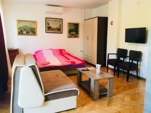 a small room with a bed and a table at Apartments Konak in Visoko