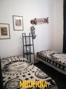 een kamer met 2 bedden en een skateboard aan de muur bij La Dimora del Marinaio in Genua