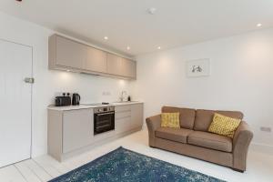 a living room with a couch and a kitchen at Dale House - Vivre Retreats in Bournemouth