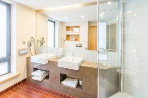 ein Badezimmer mit zwei Waschbecken und einer Dusche in der Unterkunft Hestia Hotel Europa in Tallinn