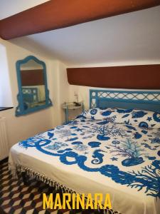 een slaapkamer met een bed met een blauwe en witte deken bij La Dimora del Marinaio in Genua