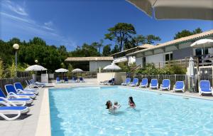 two girls playing in the swimming pool at a hotel at Résidence Odalys Bleu Ocean in Moliets-et-Maa