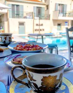 una taza de café sentada en una mesa con una pizza en Villa Olga Lounge Hotel, en Ligia