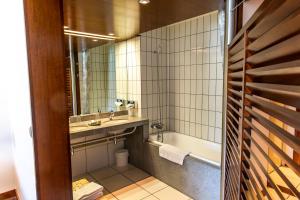 a bathroom with a sink and a tub and a toilet at Hotel Le Grand Pavois in Fécamp