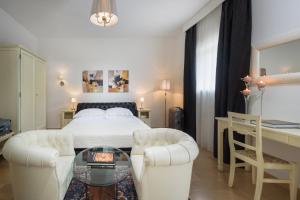 Hotel Corsignano في بينزا: غرفة نوم بسرير وطاولة وكراسي