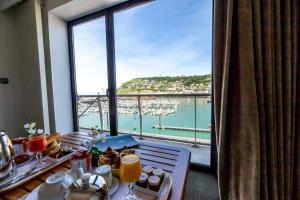 a room with a table with a view of the ocean at Hotel Le Grand Pavois in Fécamp