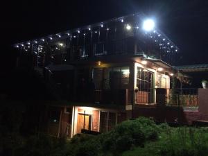 a house with a light on the roof at night at Mountside Cottages in Ooty
