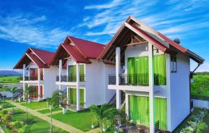 a building with green doors and red roofs at Avonil Resort Yala in Tissamaharama