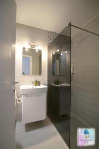 a bathroom with a sink and a mirror and a shower at 3M Apartment Skopje Center in Skopje +41 photos