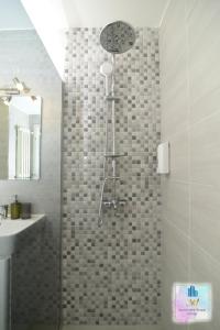 La salle de bains est pourvue d'une douche et d'un lavabo. dans l'établissement 3M Apartment Skopje Center, à Skopje