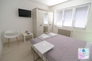 a bedroom with a bed and a table and a tv at 3M Apartment Skopje Center in Skopje