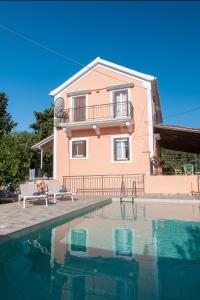 a villa with a swimming pool in front of a house at Villa Tettix (Τέττιξ) in Fiskardho