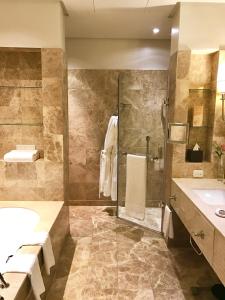 a bathroom with a shower and a sink and a tub at Taj HotelApart, Taj Hotel Cape Town in Cape Town