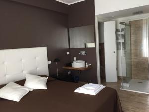 a bedroom with a bed with a sink and a shower at Itaka in LʼAquila