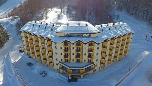 Un bâtiment avec de la neige au sommet dans la neige dans l'établissement Andrey Apartment, à Mavrovo