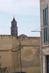 ein altes Gebäude mit einem Uhrturm im Hintergrund in der Unterkunft Casa Sassi Vizziello in Matera