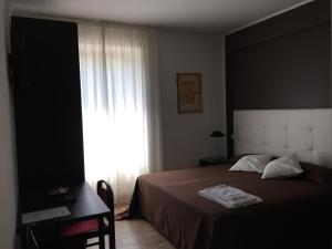 a bedroom with a large bed and a window at Itaka in LʼAquila