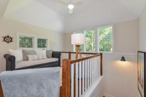 - un salon avec un escalier, un canapé et des fenêtres dans l'établissement Lake Trail Treehouse, à Saugatuck