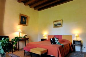 - une chambre avec un lit et une couverture rouge dans l'établissement Château de la Venerie, à Denicé
