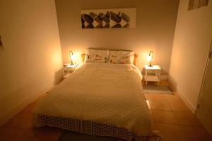 a bedroom with a bed and two lamps on two tables at La petite soixante deux in Le Lonzac
