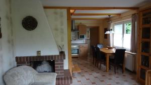 a living room with a fireplace and a table with chairs at Eule ost und west Ferienhaus im urigen Garten in Zingst +19 photos