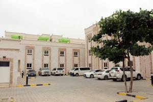 ein Parkplatz mit Autos vor einem Gebäude in der Unterkunft Al Noor Plaza in Salalah
