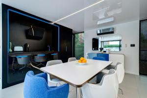 a dining room with a white table and blue chairs at Dom na Wodzie - Flohotel in Gdańsk