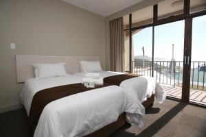 a bedroom with a large bed with a balcony at Marine Hotel in East London