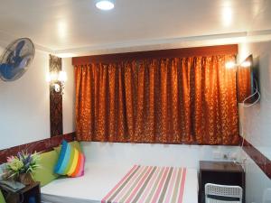 a bedroom with a bed and a window with an orange curtain at Premium Lounge in Hong Kong