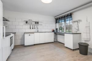 una cocina con encimeras blancas y electrodomésticos blancos en Tallbackens Gård & Vandrarhem, en Svärtinge