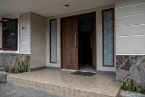 eine Eingangstür eines Hauses mit einer Veranda in der Unterkunft RedDoorz near Supermall Karawaci 2 in Tangerang