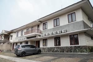 um carro estacionado em frente a um edifício em RedDoorz near Supermall Karawaci 2 em Tangerang