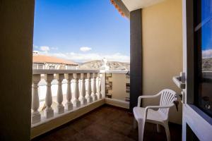 a balcony with a white railing and a white chair at Rooms in El Medano in El Médano