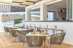 a restaurant with tables and chairs and a bar at Sol Bahía Ibiza Suites in San Antonio