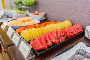 a buffet with watermelon and other foods on a table at Asoke Residence Sukhumvit by UHG in Bangkok
