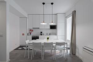 リスボンにあるCity Stays Atalaia Apartmentsの白いキッチン(白いテーブルと椅子付)
