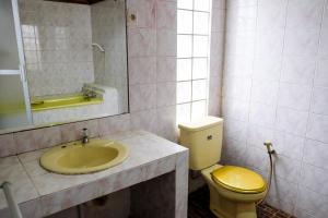 a bathroom with a yellow toilet and a sink at RedDoorz Plus near Jalan Baru Bogor in Bogor