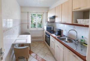 a small kitchen with a sink and a microwave at Central Apartment with Terrace in Montreux