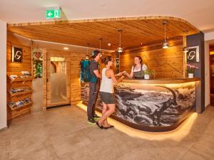 a group of people standing in front of a counter at Hotel Gundolf in Sankt Leonhard im Pitztal