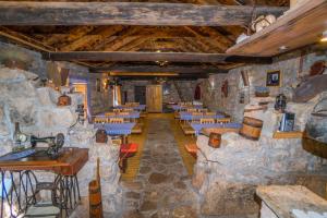 Cette chambre est dotée de murs en pierre, de tables et de chaises. dans l'établissement Agroturizam Duvančić - Konoba dida Marka, à Drniš