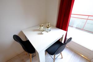 a white dining room table with two chairs and a window at Citycenter Residence in Amsterdam